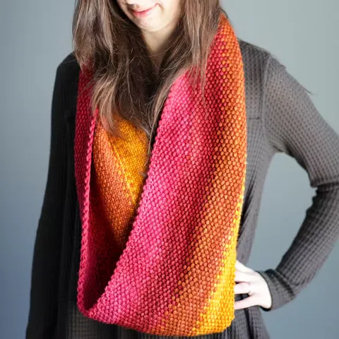 A woman wearing a multicolored (pink, orange, yellow) scarf.